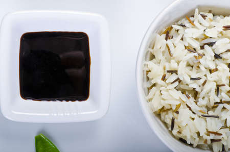 Rice and soya sauce as ingredients, on white plateの写真素材