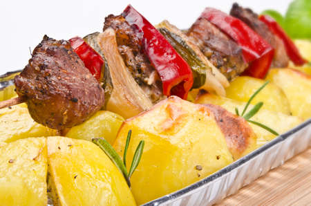 Meat spit with fried potatoesの写真素材
