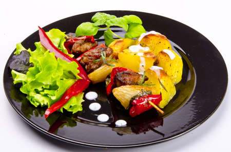Meat spit with fried potatoesの写真素材