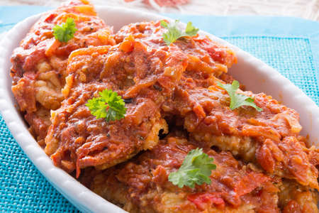 fish in Greek kind with vegetables and tomato sauceの写真素材