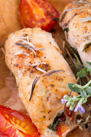 Chicken breast with spinach, baked tomatoes and herbsの写真素材