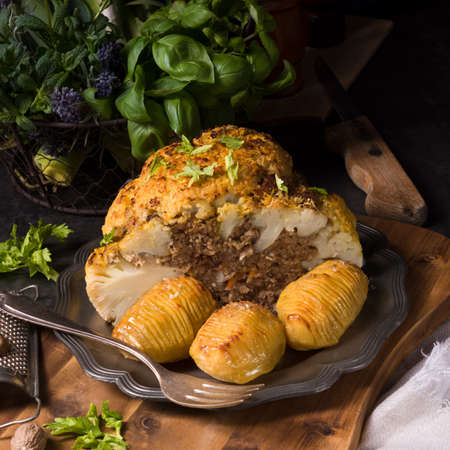 Stuffed cauliflower with mince and Hasselback potatoesの写真素材