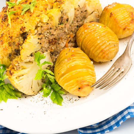 Stuffed cauliflower with mince and Hasselback potatoesの写真素材