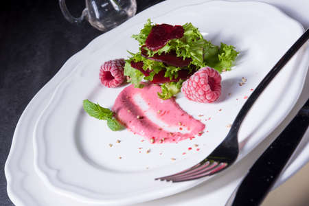 Carpaccio of baked red pray with green salad and raspberryの写真素材