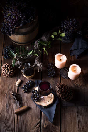 Red wine from a barrel with grapes and a glass of wineの写真素材