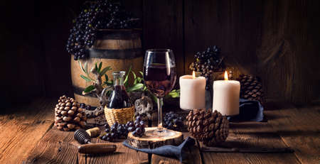 Red wine from a barrel with grapes and a glass of wineの写真素材