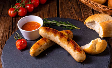 rustic bratwurst with ketchup and fresh rollsの写真素材