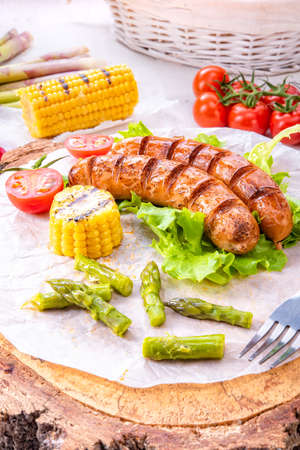 grilled krakauer sausage with boiled corn and green saladの写真素材