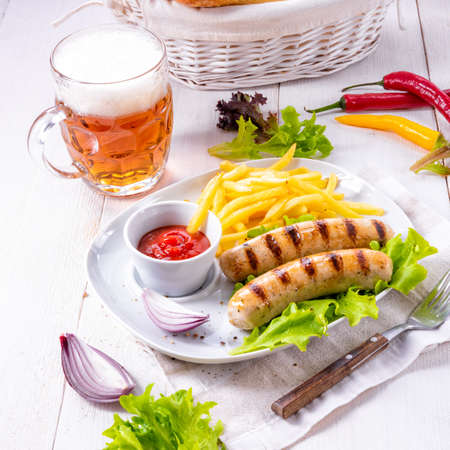 grilled bratwurst with chips and cold beerの写真素材
