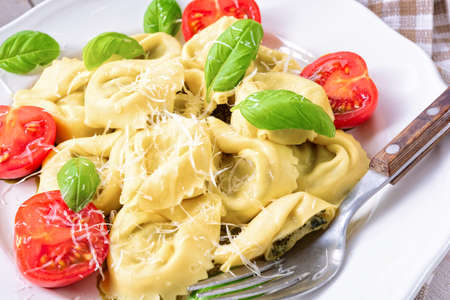 ravioli with spinach filling, grated cheese and cocktail tomatoesの写真素材
