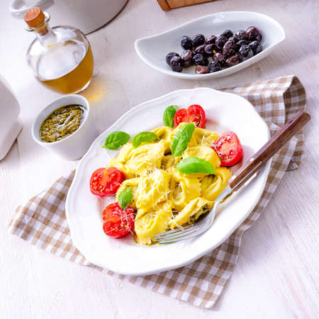 ravioli with spinach filling, grated cheese and cocktail tomatoesの写真素材