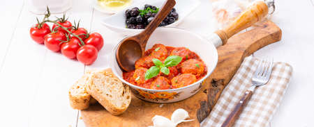 Baked mini meatballs in tomato sauce with basilの写真素材