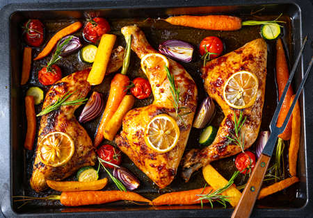 Grilled chicken legs with various vegetables and herbs.の写真素材
