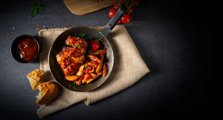 Rustic chicken wings in honey with potato wedgesの写真素材