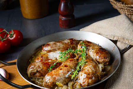 Homemade white sausage fried with onion and herbsの写真素材