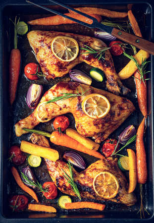 Grilled chicken legs with various vegetables and herbs.の写真素材