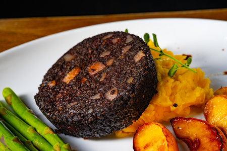 Black pudding with green asparagus and fried appleの写真素材