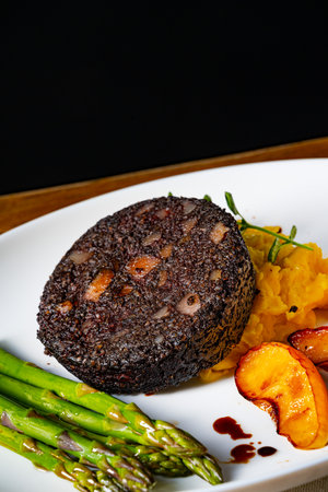 Black pudding with green asparagus and fried appleの写真素材