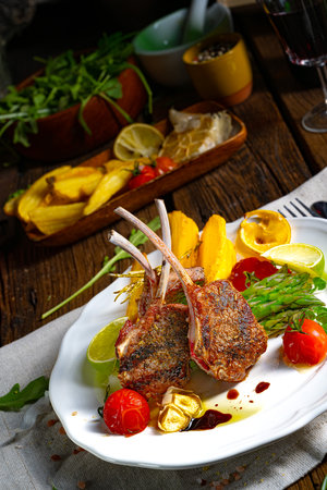 Lamb chops marinated in herbs with green asparagus and limeの写真素材