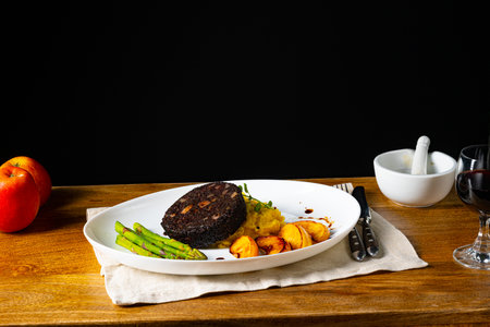 Black pudding with green asparagus and fried appleの写真素材
