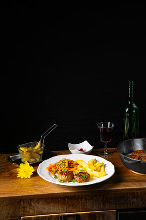 Homemade meatballs with french fries and vegetablesの写真素材