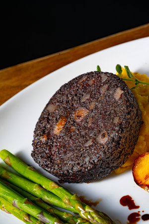 Black pudding with green asparagus and fried appleの写真素材