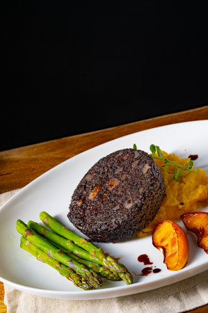 Black pudding with green asparagus and fried appleの写真素材