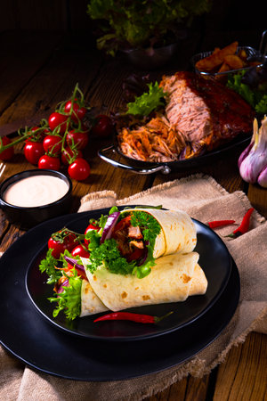 Pancakes stuffed with meat, vegetables and sauce on wooden backgroundの写真素材