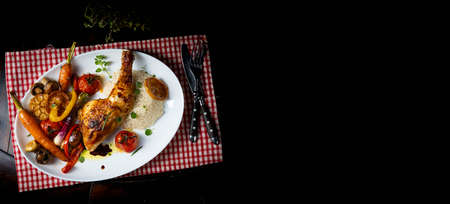 Rustic fried chicken legs with assorted vegetables and riceの写真素材