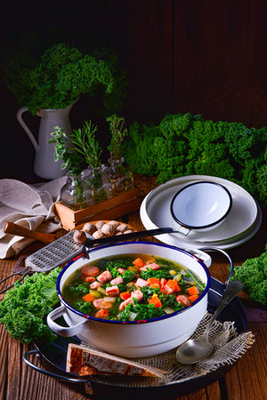 autumnal kale soup with sausage and bacon cubesの写真素材
