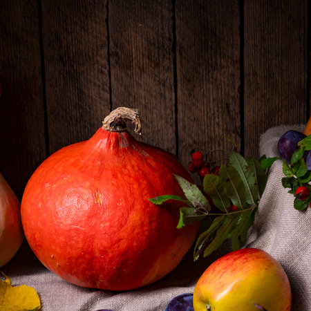 Various fruits in a wooden box with autumn leavesの写真素材