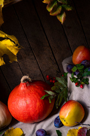 Various fruits in a wooden box with autumn leavesの写真素材