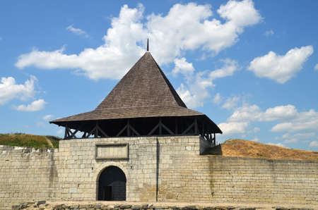 Old castle tower and stone wall. Medieval entrance gates under summer blue skyのeditorial素材