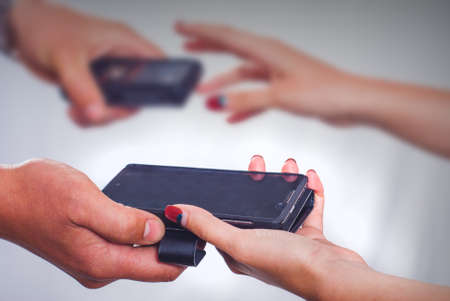 Man and woman exchange smartphones. Innovation conceptual photoの写真素材