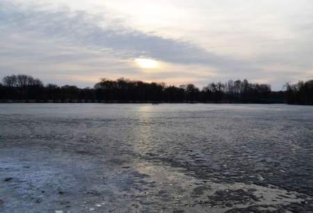 Sunset over frozen winter lake, beautiful natural backgroundの写真素材