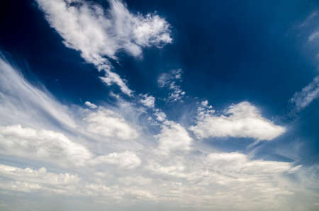 Dark blue sky background with white clouds, natural wallpaper