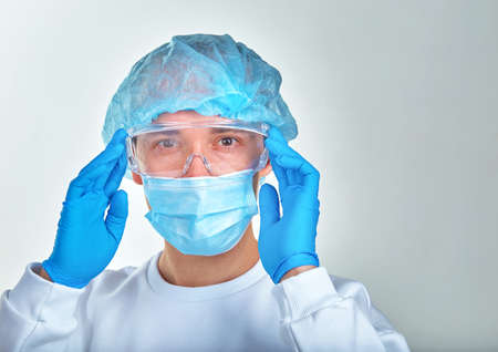Doctor in mask holding his head, medical background, wallpaper. Coronavirus disease COVID19,...