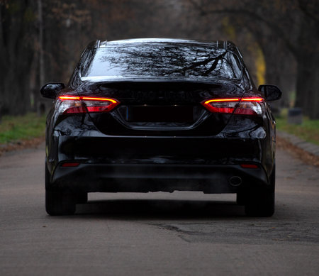 Modern car driving on a road background, car back lights wallpaperの写真素材