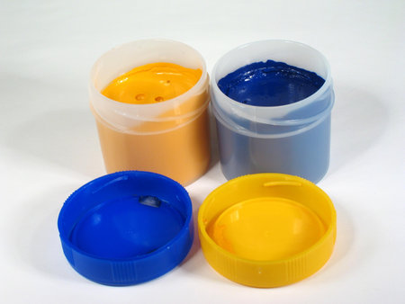 blue and yellow gouache paints in a container on a white background