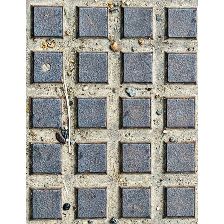 Close up of a manhole cover isolated on a white background.の写真素材