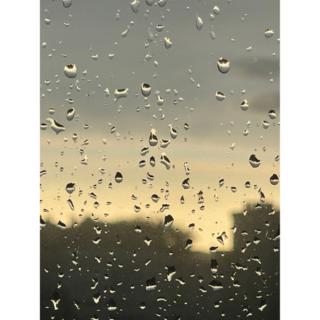 Water drops on glass. Raindrops on window glass with cityscape background.の写真素材