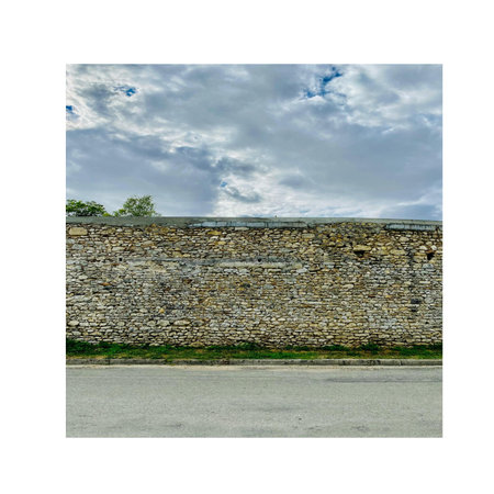 Isolated photo of a stone wall with a cloudy sky background.の写真素材