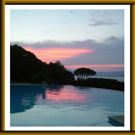 Sunset at the edge of a swimming pool in the tropicsの写真素材