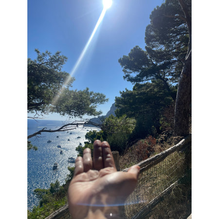 Hand of a woman on the background of the sea and mountains.の写真素材