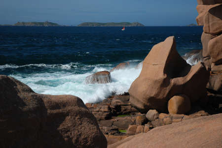 Breakers and red granite cliffの写真素材