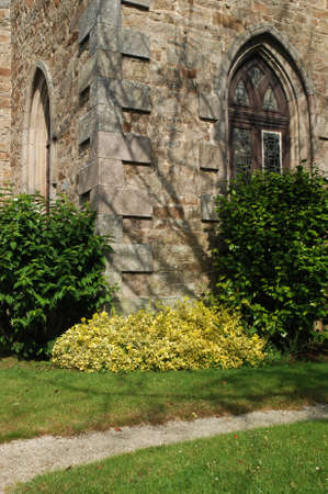 Old stone wall of church and plants in parkの写真素材