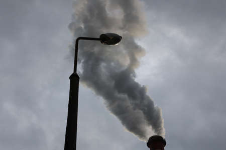 Dark smoke polluting the environment and towns and villages.の写真素材