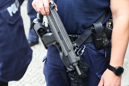 Detail of the hands of a security guard with a gun.のeditorial素材