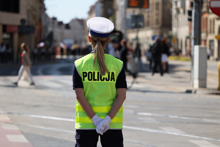 A traffic policeman in white gloves directs traffic in the city. Poland Wroclaw.のeditorial素材