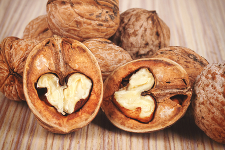 Group of cracked walnuts on wooden backgroundの写真素材